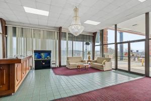 uma sala de estar com cadeiras e uma televisão e janelas em Extended Stay Suites Cookeville - Tennessee Tech em Cookeville