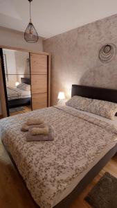 een slaapkamer met een groot bed en 2 handdoeken bij Apartment Ela in Subotica