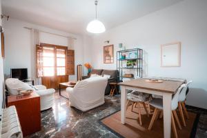 een woonkamer met een tafel en witte stoelen bij QH Gran Via 01 in Granada