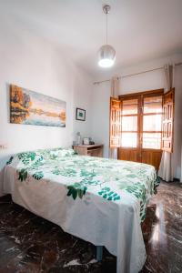 een slaapkamer met een bed met een groene deken erop bij QH Gran Via 01 in Granada