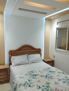 um quarto com uma cama, um espelho e uma janela em Apprtemment Sala Al Jadida em Oulad Yakoub
