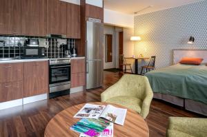 Zimmer mit einem Bett, einer Küche und einem Tisch in der Unterkunft Forenom Serviced Apartments Espoo Tapiola in Espoo