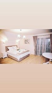 a bedroom with a large bed and a table at Seara pe deal in Coruşu