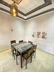 a dining room with a table and chairs and a ceiling at Appartement calme in Fez