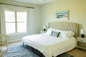 a bedroom with a large white bed with a window at Charming Brand New Home in Foley in Foley