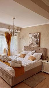 a bedroom with a large bed with white sheets at Seara pe deal in Coruşu