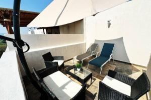 een patio met stoelen en een parasol bij Nueva y hermosa Casa familiar, relajate y disfruta in Chiconcuac