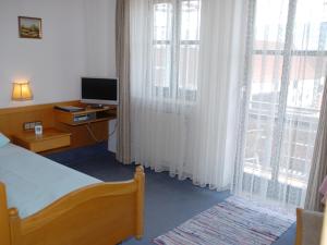 a bedroom with a bed and a television and a window at Zum Bräu-Toni in Dietfurt