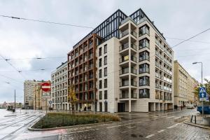 ein Apartmenthaus in einer Stadtstraße im Regen in der Unterkunft Very Berry - Zwierzyniecka 15 - City Center Apartment, Parking, self check in 24h! in Posen