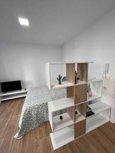 1 dormitorio con cama y estante para libros en Estudio nuevo en Benicarló, en Benicarló