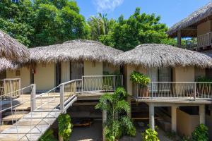 eine Gruppe von Hütten mit Strohdächern in der Unterkunft Raíz Hotel Boutique in Puerto Escondido