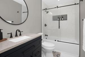a bathroom with a sink and a toilet and a mirror at Spacious home near Anschutz/DIA in Aurora +17 photos