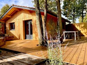 a wooden deck in front of a cabin at La Cabane 56 - calme - cosy - chaleureuse - sans vis-à-vis in Lège-Cap-Ferret