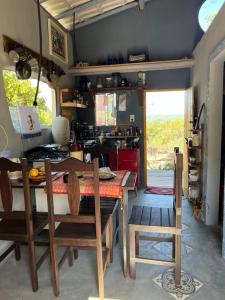 cocina con mesa y sillas en una habitación en CasaTupy Pousada, en Botumirim