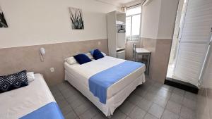a hotel room with two beds and a window at Pousada São Luiz in Aracaju
