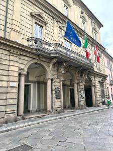 a building with three flags on top of it at Casa Del Teatro in Pavia