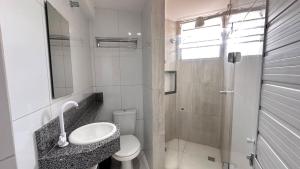 a white bathroom with a sink and a toilet at Pousada São Luiz in Aracaju