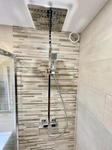 a shower in a bathroom with a tile wall at La Brise Marine ~ 300m mer~Piscine~Clim~Wifi~Calme in Argelès-sur-Mer