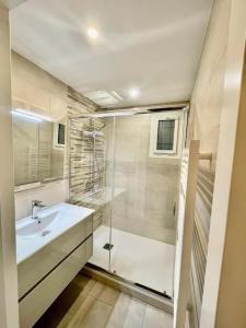 a white bathroom with a sink and a shower at La Brise Marine ~ 300m mer~Piscine~Clim~Wifi~Calme in Argelès-sur-Mer