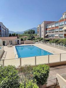 a large swimming pool in the middle of a building at La Brise Marine ~ 300m mer~Piscine~Clim~Wifi~Calme in Argelès-sur-Mer