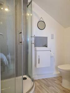 La salle de bains est pourvue d'une douche en verre et de toilettes. dans l'établissement 6 En-Suite Bedrooms; Garden; Driveway;Pet Friendly, à Bournemouth