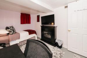 a room with a bed and a fireplace and a television at Quaint & Cozy Accommodation in Edmonton