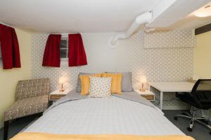 Quaint & Cozy Accommodation في إيدمونتون: غرفة نوم بسرير وكرسيين ومكتب