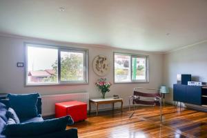 a living room with a couch and a table and windows at Estilo Valdiviano, depto2D/1B in Valdivia