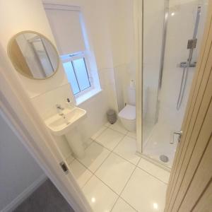 a bathroom with a shower and a sink and a mirror at Luxury 3 bedroom house on the outskirts of Newcastle near to Hadrians Wall in Newcastle upon Tyne