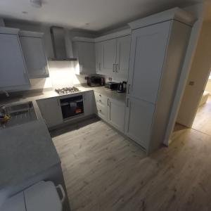 an overhead view of a kitchen with white cabinets at Luxury 3 bedroom house on the outskirts of Newcastle near to Hadrians Wall in Newcastle upon Tyne