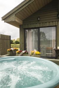 un bain à remous en face d'une maison dans l'établissement Green Valley vacation homes, à Žocenes Ciems