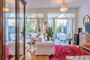فيلا عايده في ميلانو: غرفة معيشة مع أريكة بيضاء وسجادة حمراء