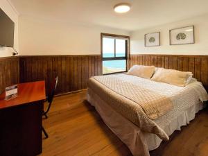 Un dormitorio con una cama y un escritorio y una ventana. en Hotel Bután Coronel, en Coronel 34 fotos más