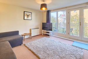 a living room with a couch and a tv at Host & Stay - Bingley Court in Canterbury