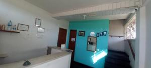 a room with a blue wall with a refrigerator at Pousada Elefantinho in São Pedro da Aldeia