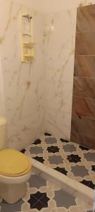baño con aseo amarillo y pared de mármol en Tayrona Shalom Bait, en Santa Marta