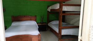 1 dormitorio con 2 literas y una pared verde en Tayrona Shalom Bait, en Santa Marta