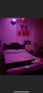 a purple bedroom with a bed and a purple light at Residencia del Oriente in Bucaramanga