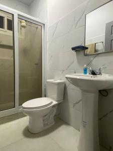 biała łazienka z toaletą i umywalką w obiekcie Céntrico Apartamento w mieście Santa Rosa de Copán