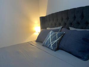 1 dormitorio con 1 cama con almohadas azules y lámpara en Céntrico Apartamento en Santa Rosa de Copán
