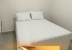 a bed with white sheets and pillows in a room at APARTAMENTO ENCANTADO V. MARIA 9 in Foz do Iguaçu