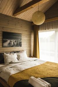 a bedroom with a large bed and a large window at Green Valley vacation homes in Žocenes Ciems