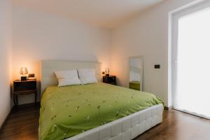 a bedroom with a bed with a green comforter at Pinzolo Ski Lodge Retreat in Pinzolo