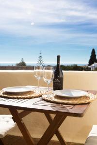 a table with two glasses and a bottle of wine at Casa Sol e Mar in Carvoeiro