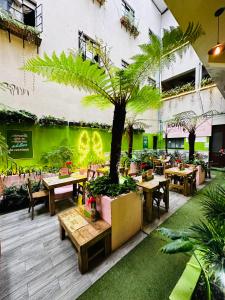 a restaurant with tables and a palm tree in the middle at Roma Norte Hostal in Mexico City