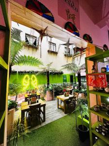 a restaurant with tables and plants on the wall at FRONTERA 49 Roma Norte Hostal in Mexico City