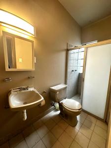 a bathroom with a toilet and a sink at FRONTERA 49 Roma Norte Hostal in Mexico City