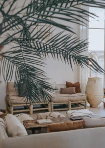 a living room with a couch and a palm tree at HAERT Boutique Wellness Suites City Centre in Haarlem