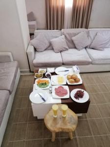 a living room with a couch and a table full of food at pyravista in ‘Ezbet `Abd el-Ḥamîd