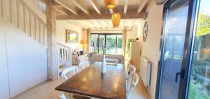 a dining room with a wooden table and white chairs at La Cantonada II in Bourg-Madame